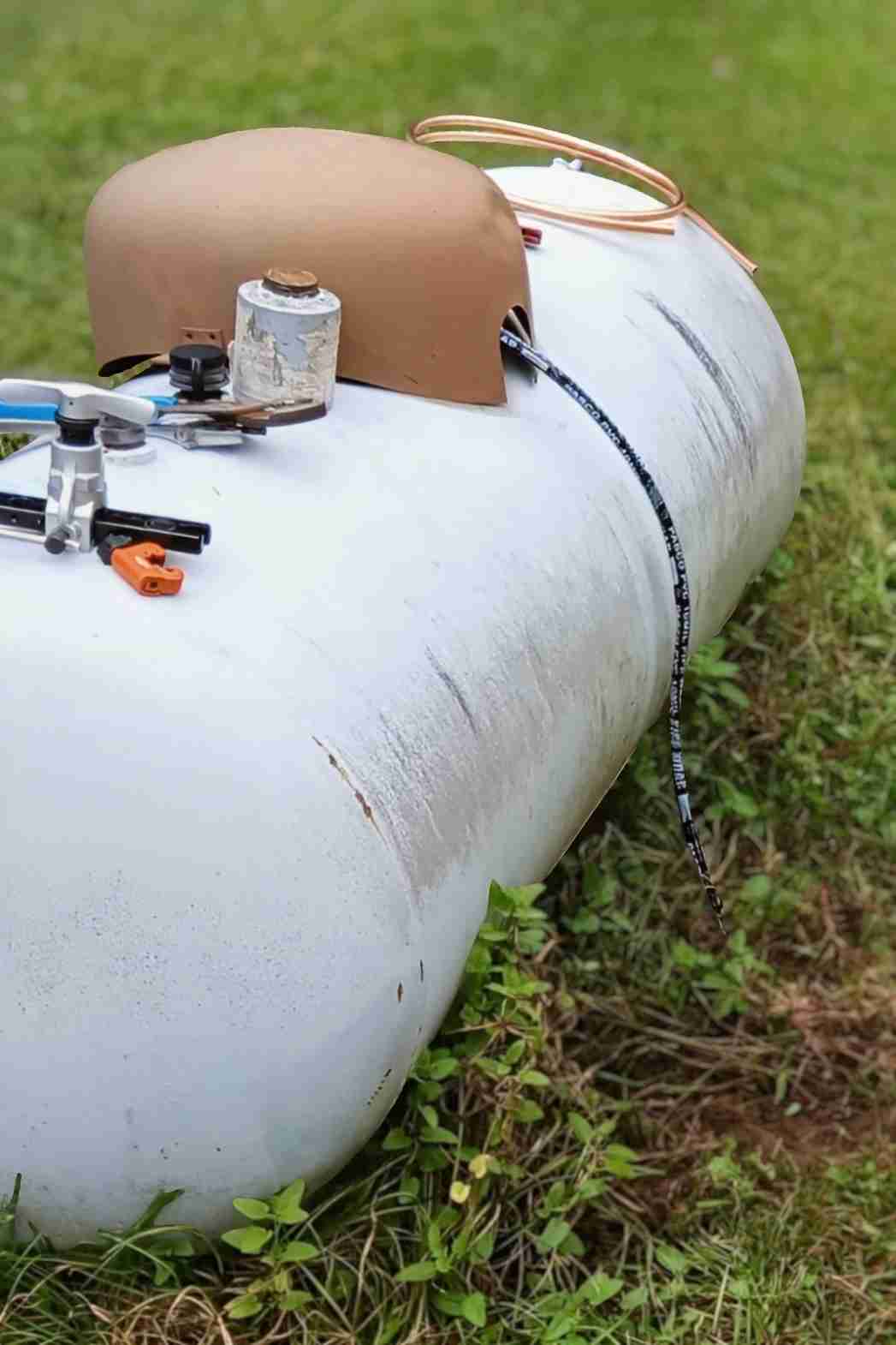 Residential plumbing propane gas line replacement showing a propane tank connection and new copper line.